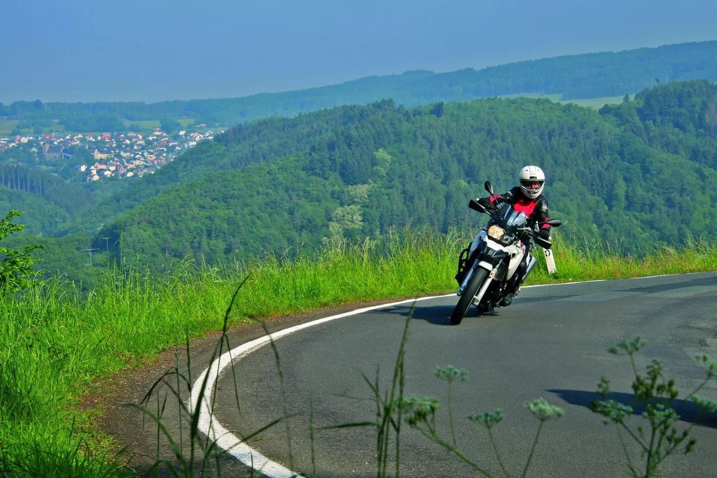 Motorrad in einer Kurve mit weitem Blick ins Tal Motorrad in einer Kurve mit weitem Blick ins Tal